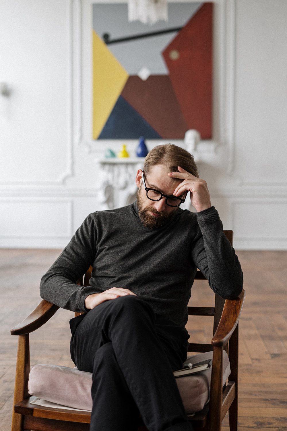 Man in Black Sweater Sitting on Brown Wooden Chair